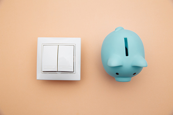 Stromsparen im Haushalt Symbolbild Sparschwein und Lichtschalter